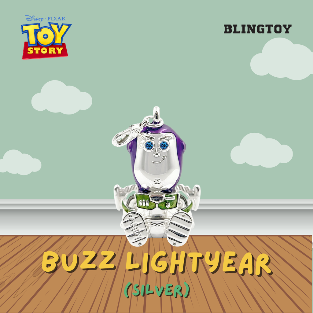 A silver Buzz Lightyear charm pendant from Disney Pixar Toy Story, displayed against a light green sky and wood floor backdrop with 'BLINGTOY' and 'TOY STORY' branding.