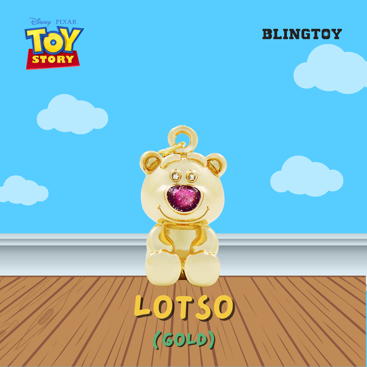 A gold Lotso bear pendant charm from Disney Pixar Toy Story, featuring a sparkling pink heart-shaped nose, displayed on a wooden floor against a blue sky background with clouds. The image includes 'BLINGTOY' and 'TOY STORY' branding.