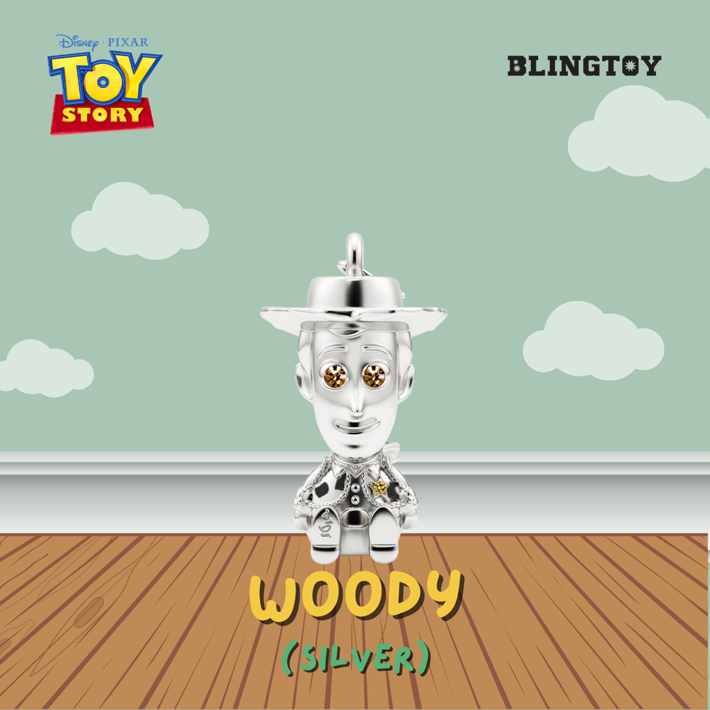 A silver Woody character charm from Disney Pixar Toy Story, shown against a stylized background with a mint green sky, white clouds, and a brown wooden floor. The text 'WOODY (SILVER)' is displayed at the bottom.